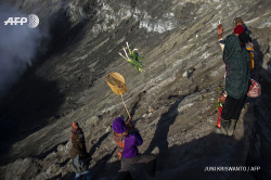 afp-photo:  INDONESIA, PROBOLINGGO : Scavengers stand on the inner wall of Mount  Bromo volcano to catch offerings by members of the Tenggerese tribes in  Probolinggo town located in eastern Java island on August 1, 2015.   Tenggerese are Hindu believers