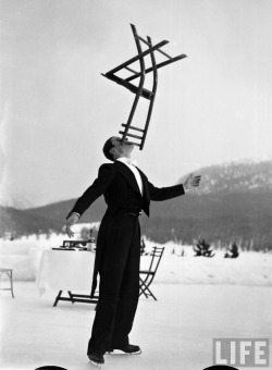 Alfred Eisenstaedt - Head waiter Rene Breguet balancing chair on chin at ice rink of Grand Hotel, St. Moritz, Switzerland, 1932.