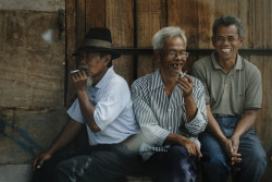 Three men smoking and laughing. Bandung, Indonesia