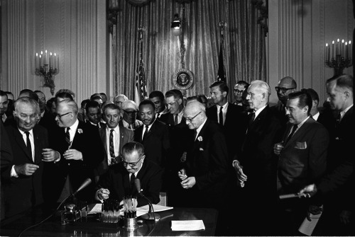 howstuffworks:  todaysdocument:  On July 2, 1964, with Martin Luther King, Jr., directly behind him, President Lyndon Johnson scrawled his signature on a document years in the making—the Civil Rights Act of 1964. This year marks the 50th anniversary