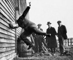 Tests de solidité des premiers casques pour le football américain, 1912.Un homme se jette tête la première contre une palissade afin de déterminer la résistance aux chocs du prototype. 