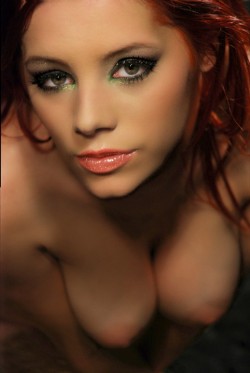 Beautiful closeup of gorgeous redhead Ariel with her breasts hanging and amazing looking eyes.
