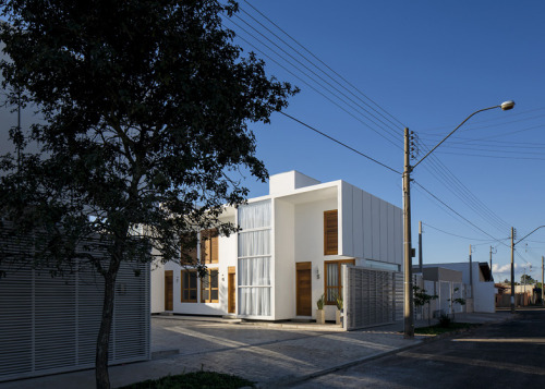 cjwho:  AV Houses, São Paulo, Brazil by Corsi Hirano Arquitetos The line of the roof extends out over the extruded glass-fronted boxes that house the staircases, creating shelters over the entrances. Half the residences have these stairs at the front