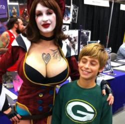 grimphantom:  dorkly:  Kid Caught Sneaking a Peek at Mad Moxxi Cosplayer and Adult Model Ariene St. Amour gives a young man the opportunity to experience Borderlands 2 in HDD.  Grimphantom: The kid is not dumb here lol.  wana punch the little shit! lol