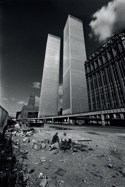 redhousecanada:  Two homeless men squat in the shadow of the recently completed World Trade Center in October, 1975. New York City was on the verge of bankruptcy and the World Trade Center sat largely vacant.- Jean Pierre Laffont