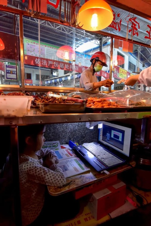 sixpenceee:  Chinese kid taking online class under her parents’ street food stand. Ke Enya is a first-grader from a primary school in Yuyangguan township in Wufeng Tujia autonomous county in the city of Yichang, central China’s Hubei province. After