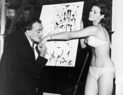 collectivehistory:  Salvador Dalí kisses 25-year-old Raquel Welch’s hand in front of his abstract portrait of her, 1965.  