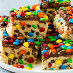 foodffs:  These cookie dough bars are edible cookie dough filled with chocolate chips and M&amp;M’s, then topped with more chocolate and candy. A fun and unexpected dessert that takes just minutes to put together!  #cookiedoughbars  #ediblecookiedough