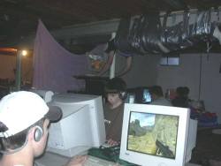 puckish-thoughts:  THERE IT IS AGAIN!  THERE IT FUCKING IS!  i’VE BEEN TALKING ABOUT THIS PHOTO FOR YEARS AND NEVER COULD FIND IT!!  THE LAN PARTY WITH THE GUY DUCT-TAPED TO THE CEILING!!  BACK IN ANCIENT TIMES WHEN PEOPLE STILL USED CATHODE MONITORS