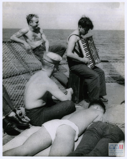 sailorgil:  “ The Accordion Player “  …   Crewmen listening to a musical shipmate’s selections (on an accordion) on the forward turret of a five inch gun aboard the USS Saratoga – en route to battle.” 18 January 1944   