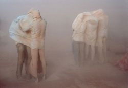 unrar:    Refugees in the desert. People engulfed in a sandstorm waiting for it to subside, in Sha-allan camp 1990, Jordan. Chris Steele-Perkins. 