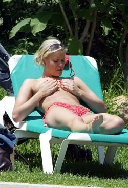 toplessbeachcelebs:  Suzanne Shaw (British Actress) sunbathing topless but covering up (July 2005) 