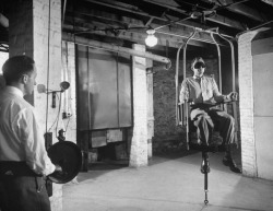 During stress, patient is strapped in a suspended armchair and whirled rapidly, after which a normal patient would be dizzy but a psychotic will not. Location: Worchester, MA, US Date taken: August 1949