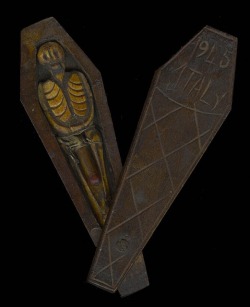 A WWII trench art coffin with a skeleton inside. The coffin lid, marked Italy 1945, slides open to reveal a skeleton. When the lid opens, the skeleton reveals an erected penis.