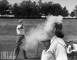 Trick-shot champion Bob Geesey, a cop in York, Pennsylvania, blasts a pipe from his wife’s mouth during a demonstration of his shooting skill in 1948.