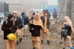 afp-photo:  PAKISTAN, Peshawar : Pakistani children arrive at their school in Peshawar on December 20, 2014, after three days of mourning for the children and staff killed by Taliban militants in an attack on an army-run school. A Taliban massacre at