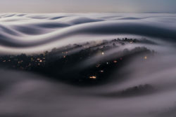 mega-hippobumhole:  sixpenceee:  Italian photographer Lorenzo Montezemolo climbed Mt. Tamalpais to capture Marin County, California covered with a river of fog lit by a full moon. He later wrote that he had “compressed 186 seconds of moonlit fog into