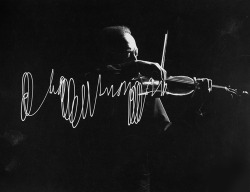 Jascha Heifetz playing violin in Mili’s darkened studio as light attached to his bow traces the bow movement. Photo by Gjon Mili,1952.