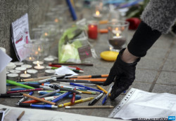 afp-photo:  FRANCE, Strasbourg : A woman places a pen in the central square of the French eastern city of Strasbourg on January 8, 2015, to pay tribute to the victims of an attack by armed gunmen on the offices of French satirical newspaper Charlie Hebdo