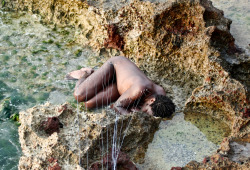 raveneuse:  Carlos Martiel, Subject, 11th Havana Biennial, Collective Behind the Wall, Havana, Cuba, 2012. Curated by Juan Delgado“I lie in the fetal position on the seashore, several hooks attached to my skin by fishing wire hold me to the sea wall.”