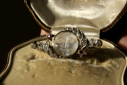 cemeterywind:  Late Victorian brooch with a man in the moon cameo carved from transparent moonstone, set in white and rose gold with a border of diamonds and rubies.