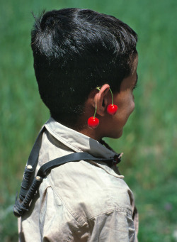 hopeful-melancholy:   A young boy carries his slingshot around his neck and wears cherries like earrings in Gilgit, Khyber Pakhtunkhwa, Pakistan.   Ric Ergenbright 