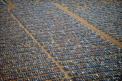 mansfrombelow:  canadian-communist:  Where the World’s Unsold Cars Go to Die Above are photos of thousands and thousands of brand new, unsold cars in various locations from the U.S., Italy, U.K., Spain, Russia, and elsewhere.  Millions of unsold cars