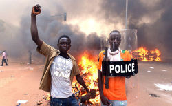 politics-war:  Protesters pose with a police shield outside the parliament in Ouagadougou on October 30, 2014. 
