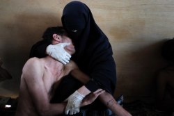 blue-voids:  Samuel Aranda - Yemen, 2012 Captured in Yemen, this photograph portrays an unusual moment of intimacy: a young, injured, and shirtless man is cradled in the arms of a veiled woman, who is covered head-to-toe in the niqab. 