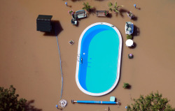politics-war:  A garden with a swimming pool is inundated by the waters of the Elbe River during floods near Magdeburg in the state of Saxony Anhalt, on June 10, 2013. Tens of thousands of Germans, Hungarians and Czechs were evacuated from their homes