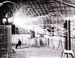 Multiple exposure publicity picture of Tesla sitting in his Colorado Springs laboratory with his &ldquo;Magnifying transmitter&rdquo; generating millions of volts and producing 23 feet long arcs.