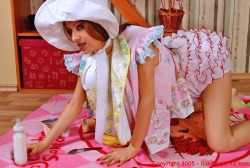 stepmotherslaw:  Zoe would have still looked like an adult if it wasn’t for the blatant babyish clothing that covered her body. A massive white and pink bonnet, a yellow plastic bib around her neck and a huge, puffy diaper covered by pink and red frilly