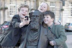 molly23:  nprbooks:  artjonak:  The great-great-great grandchildren of Dickens take a selfie with him on his 202nd birthday.  Although the author himself hoped to avoid such commemoration, a statue of Charles Dickens was unveiled last week just in time