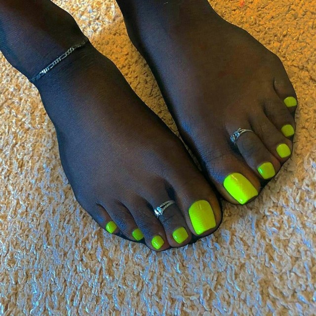 Yellow toes under black pantyhose.