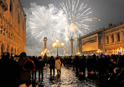 People watch New Year&rsquo;s Eve fireworks over Venice&rsquo;s St. Mark square flooded by high water, early Friday, Jan. 1, 2010. (AP Photo/Luigi Costantini)