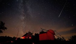 inothernews:  HIDE AND STREAK  A bright Perseid meteor streaks over buildings at the Stellafane amateur astronomy convention in Springfield, Vt., on Aug. 7.  (Photo: Dennis di Cicco / Sky &amp; Telescope via MSNBC.com) 