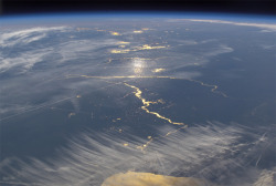 maxistentialist:  A photograph of sunlight reflected by waterways  across the central United States, as seen from the International Space  Station in November of 2003. The scene looks southwest from above Lake  Michigan across the Illinois and Mississippi