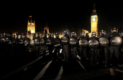 Police officers in riot wear contain student protesters on Westminster Bridge on December 9, 2010 in London, England. (Oli Scarff/Getty Images)
