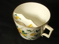 misleadthoughts:  This is a moustache cup. It was used in the Victorian times, if you has a particularly large moustache, you would rest the moustache on the little ledge bit inside the cup, and drink through the hole, to avoid getting your moustache