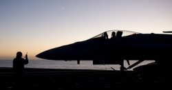 youlikeairplanestoo:  Beautiful dusky silhouetted photo of this F-18 driver being directed across the deck of the USS Carl Vinson (CVN 70). PACIFIC OCEAN (Sept. 29, 2011) An Aviation Boatswain’s Mate (Handling) assigned to Air Department’s V-1 Division