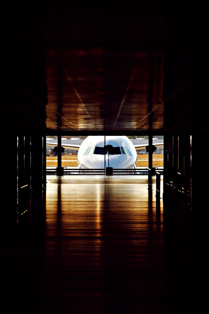 youlikeairplanestoo:  A lonely Airbus peeking inside a dark terminal. A bit like King Kong looking peering inside of a skyscraper :) Photo by Jorgen Syversen. Used with permission. Full version here. 