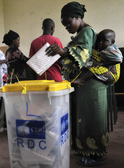 fotojournalismus:  A Congolese woman carrying her baby casts her vote in Goma during the presidential and legislative elections on November 28, 2011. The Democratic Republic of Congo held national elections Monday under a cloud of violence after clashes