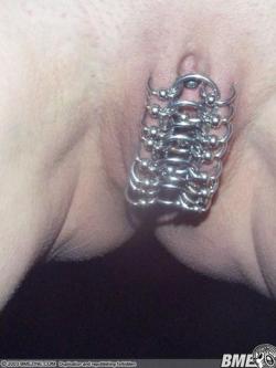 Numerous labia rings linked by other rings. Entry barred, chastity piercing.