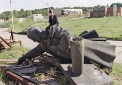 Una joven de Lituania se sienta en la caída estatua del líder bolchevique Vladimir Lenin en Vilnius, luego de que el monumento fuera sacado del centro de la capital de Lituania, el 1 de Septiembre de 1991. | A young Lithuanian girl sits on the toppled