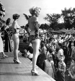 Young men ogle showgirls on the bally stage of a carnival Girlie-Show, during the 1950 Michigan State Fair..
