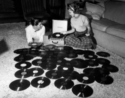  Young couple playing records spread out on living room floor. Ohio, 1955. 