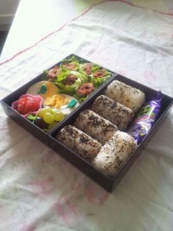 My attempt at Bento ! Lamb sheesh kebabs wrapped in fresh curly leaf lettuce, A boiled egg, strawberrys, grapes, 5 mini Onigiri, two which contain egg mayo and three which have Dried cod Furikake mixed into them and a mini choclate treat ! 