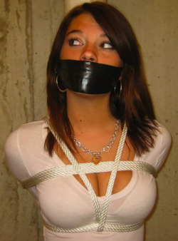 flushmotor:  found-images: That tape will certainly keep her quiet.  Too bad it also prevents her from using her lips and tongue. Nice use of the rope too.  Serves not only to restrain her, it shows of two of her better “assets” I’d love to know