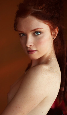 Beautiful redhead with perky breasts and piercing eyes.