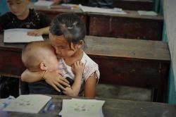 thegirlwiththefeathertattoo:  Very inspirational picture. Education is our key to success! A student is holding her little brother while in school because her single mother works for their living. Thanks for her understanding teachers and classmates.